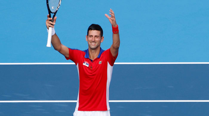Novak Djokovic holding up a tennis racket